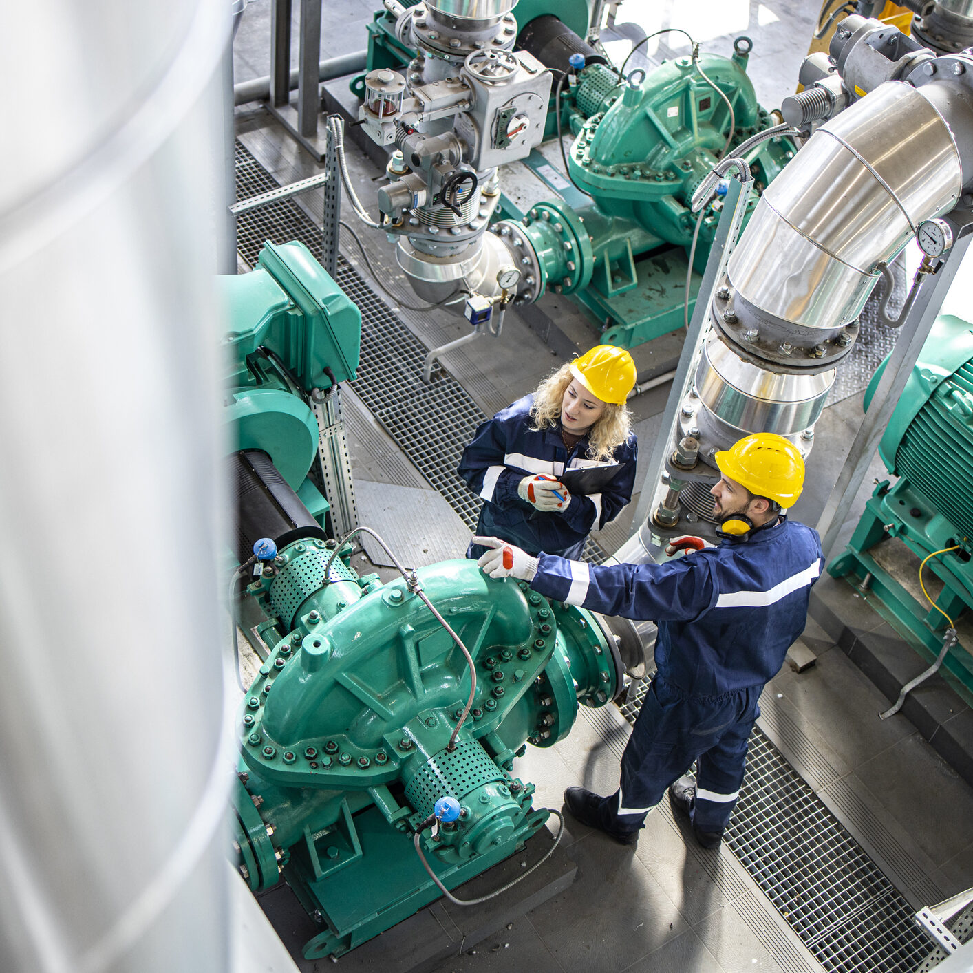 Refinery workers or engineers inspecting gas pipes and generators functionality. Petrochemical industry and oil production.